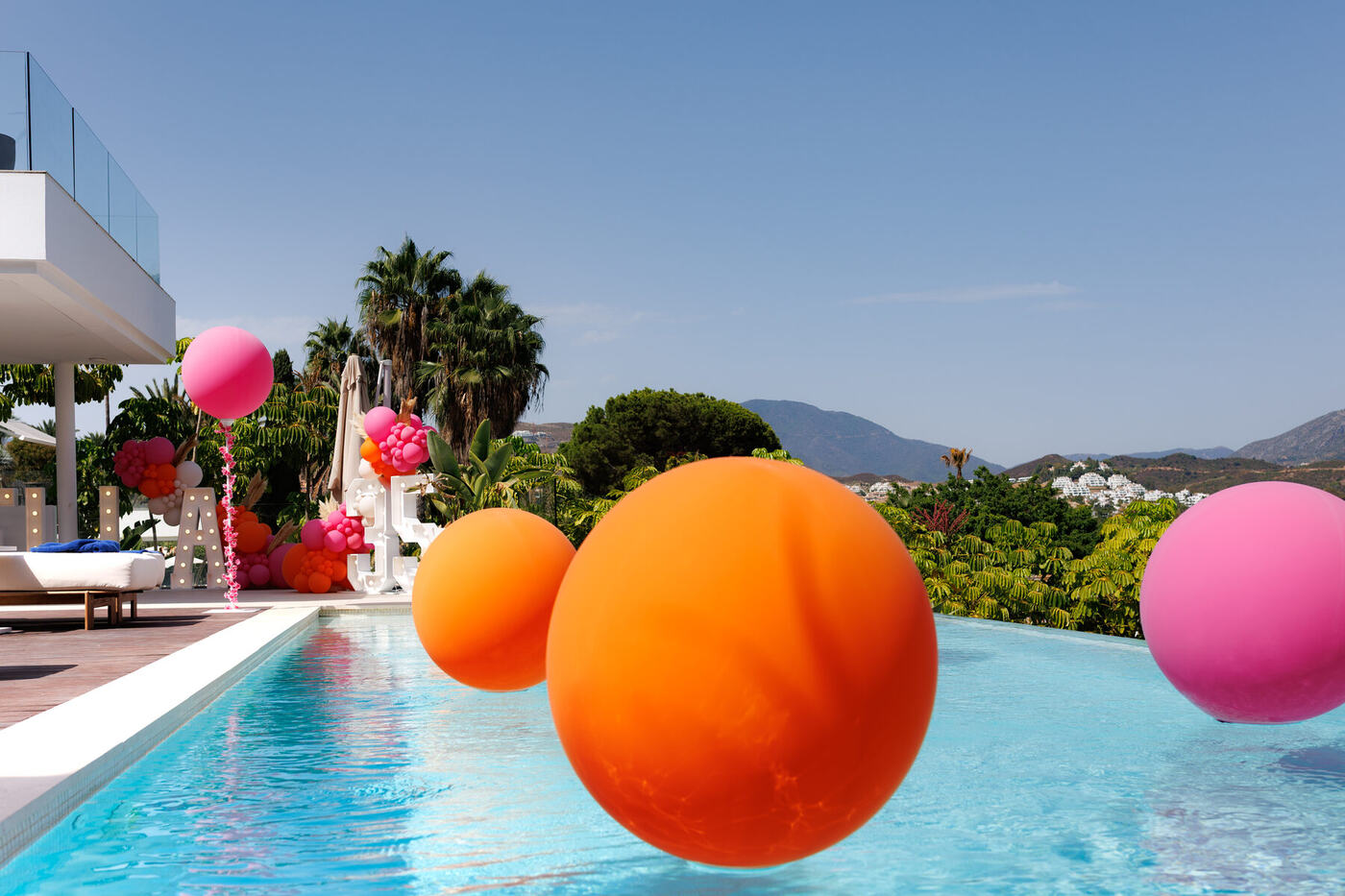 Balloon Man Spain team member beside the BRICHELLA marquee letters, Marbella