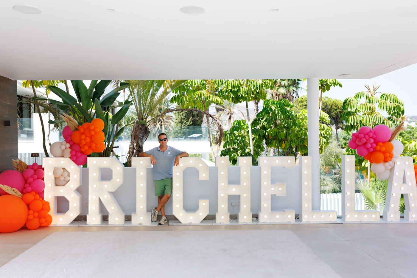 Balloon Man Spain team member beside giant light-up BRICHELLA marquee letters, Marbella villa