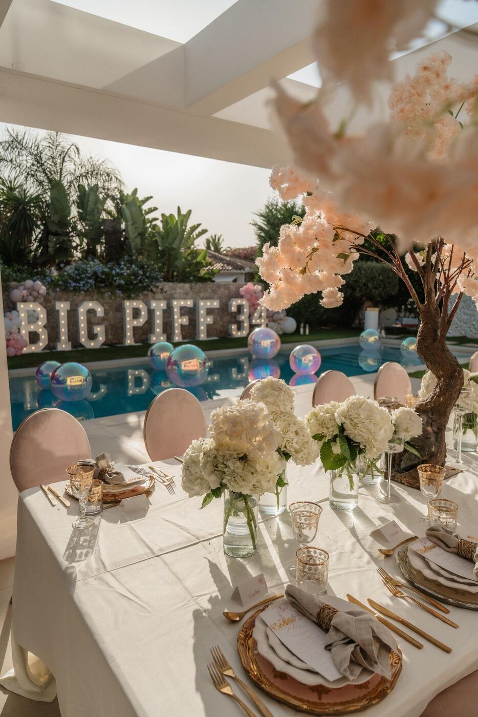 Poolside table setting with cherry blossom tree and pool orbz, Marbella birthday