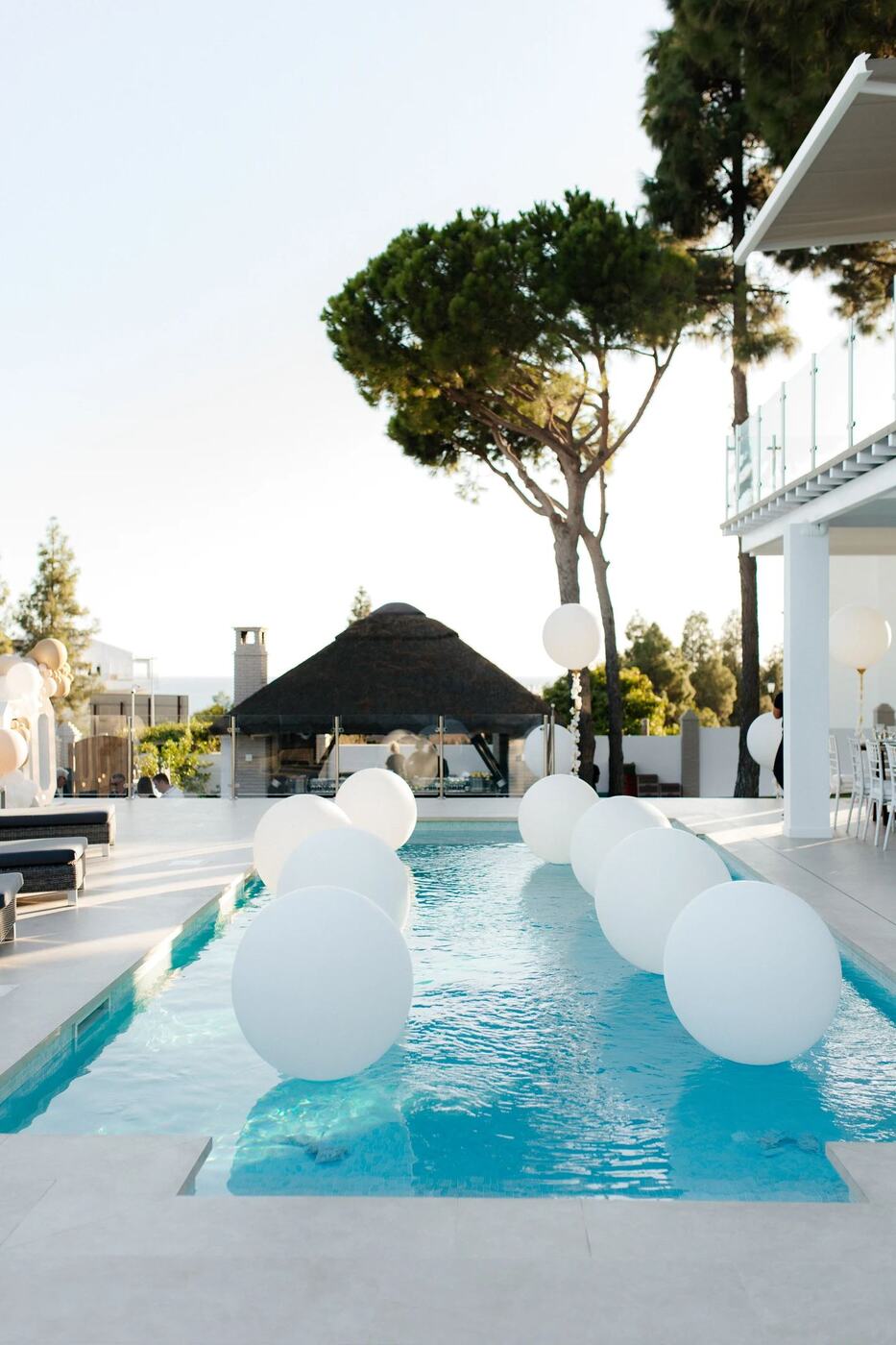 Floating white orb balloons along a villa pool in Mijas