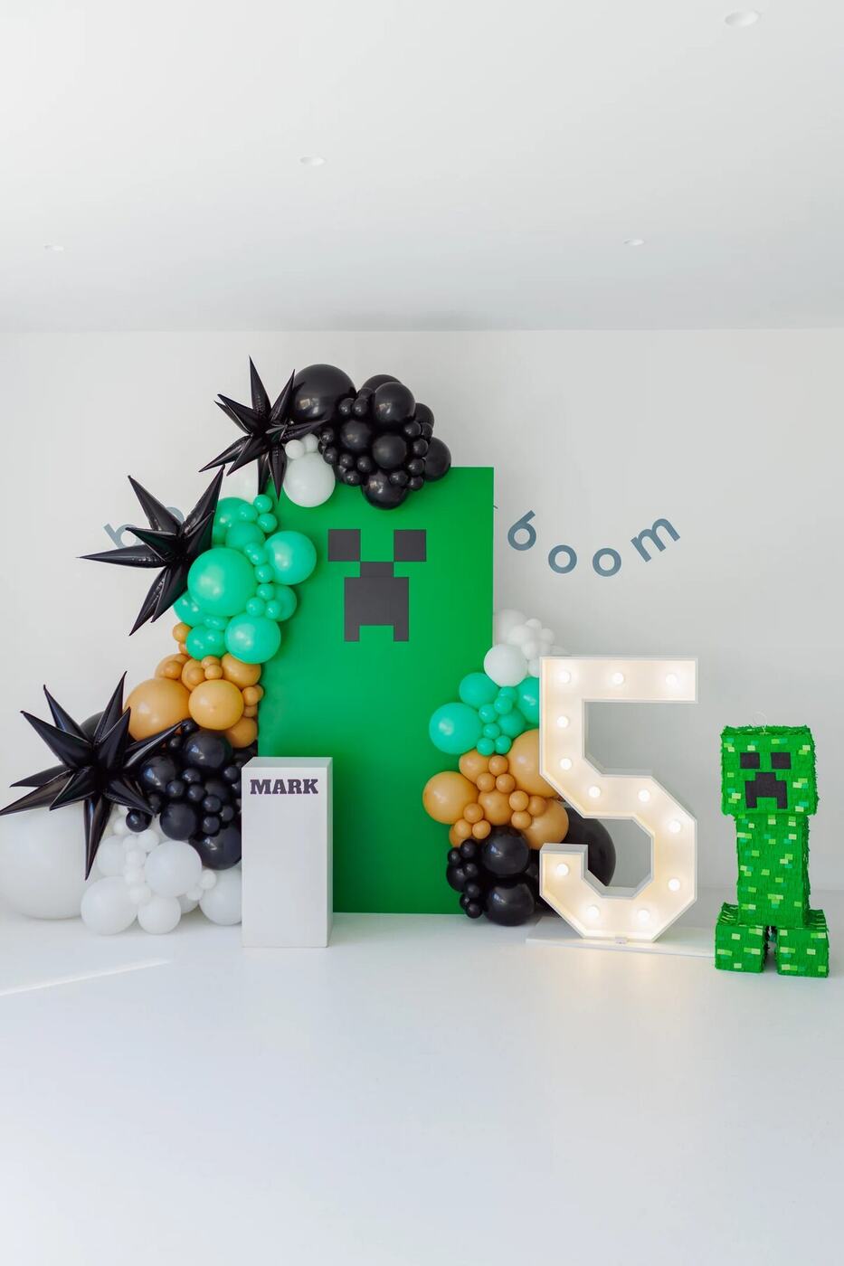 Extra-tall green Creeper backdrop with black and tan balloon clusters and light-up 5 numbers, Minecraft birthday Marbella