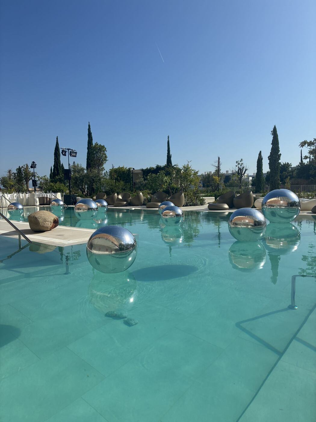 Reusable mirrored orbz floating pool display at El Higuerón, Benalmádena