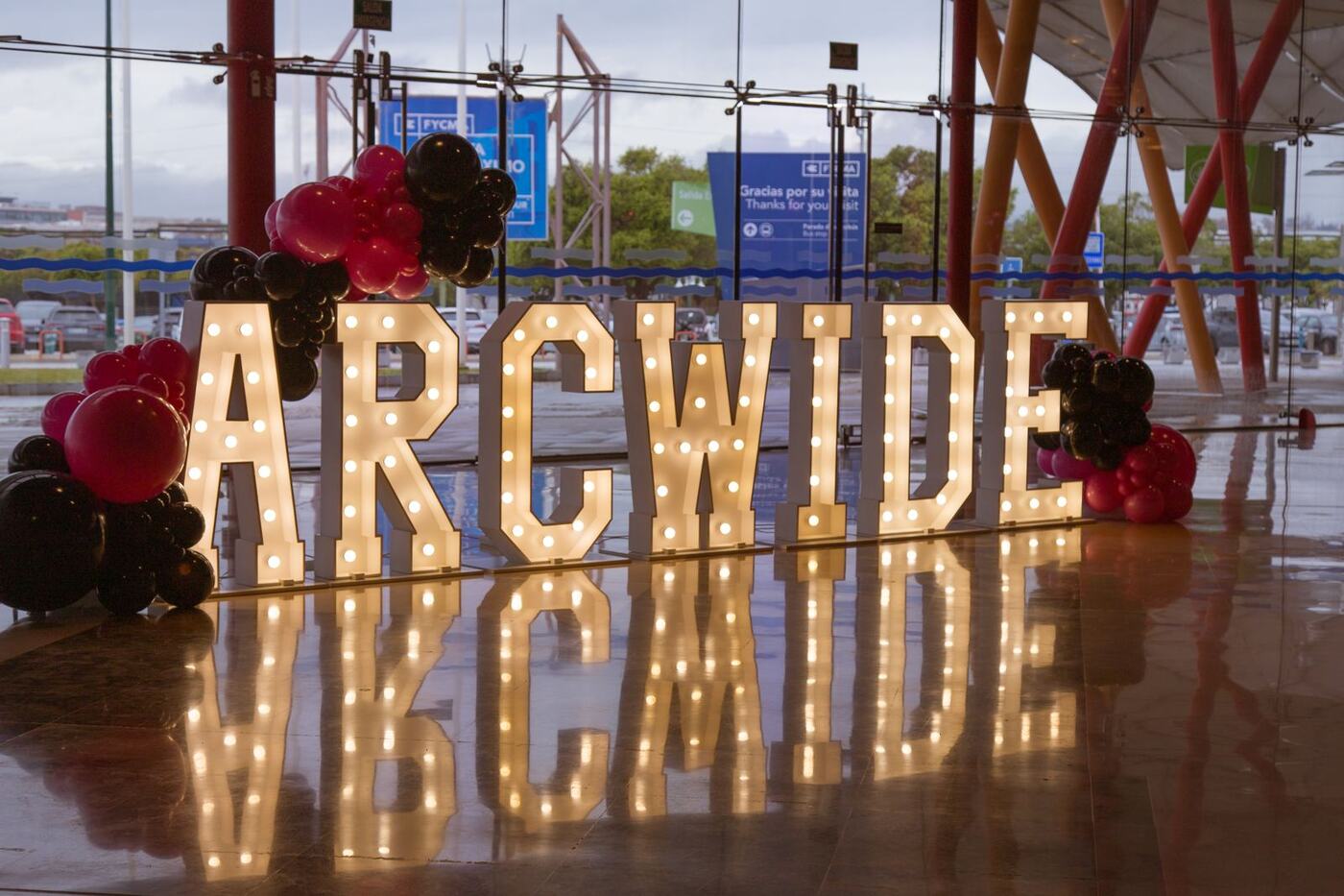 ARCWIDE marquee letters with black and pink balloon clusters, corporate event Marbella
