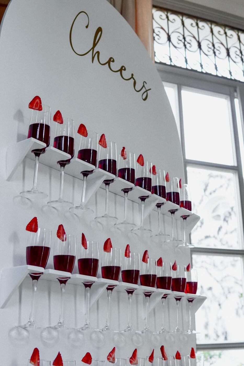 White arch champagne wall with Cheers lettering, glasses and strawberries, 18th birthday Marbella