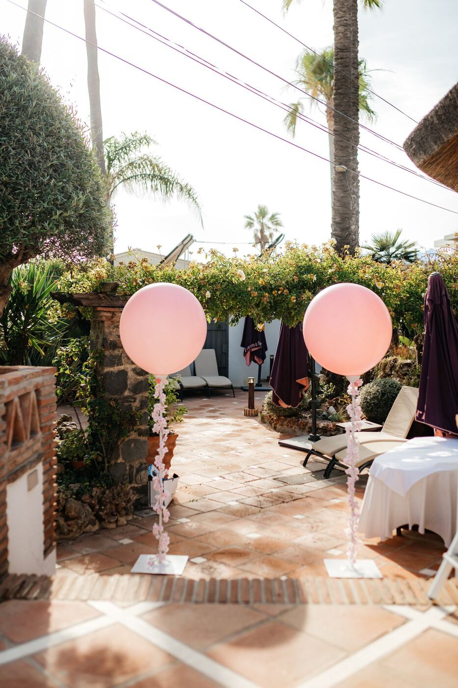 Elegant pink balloon columns with flower garland tails, Marbella