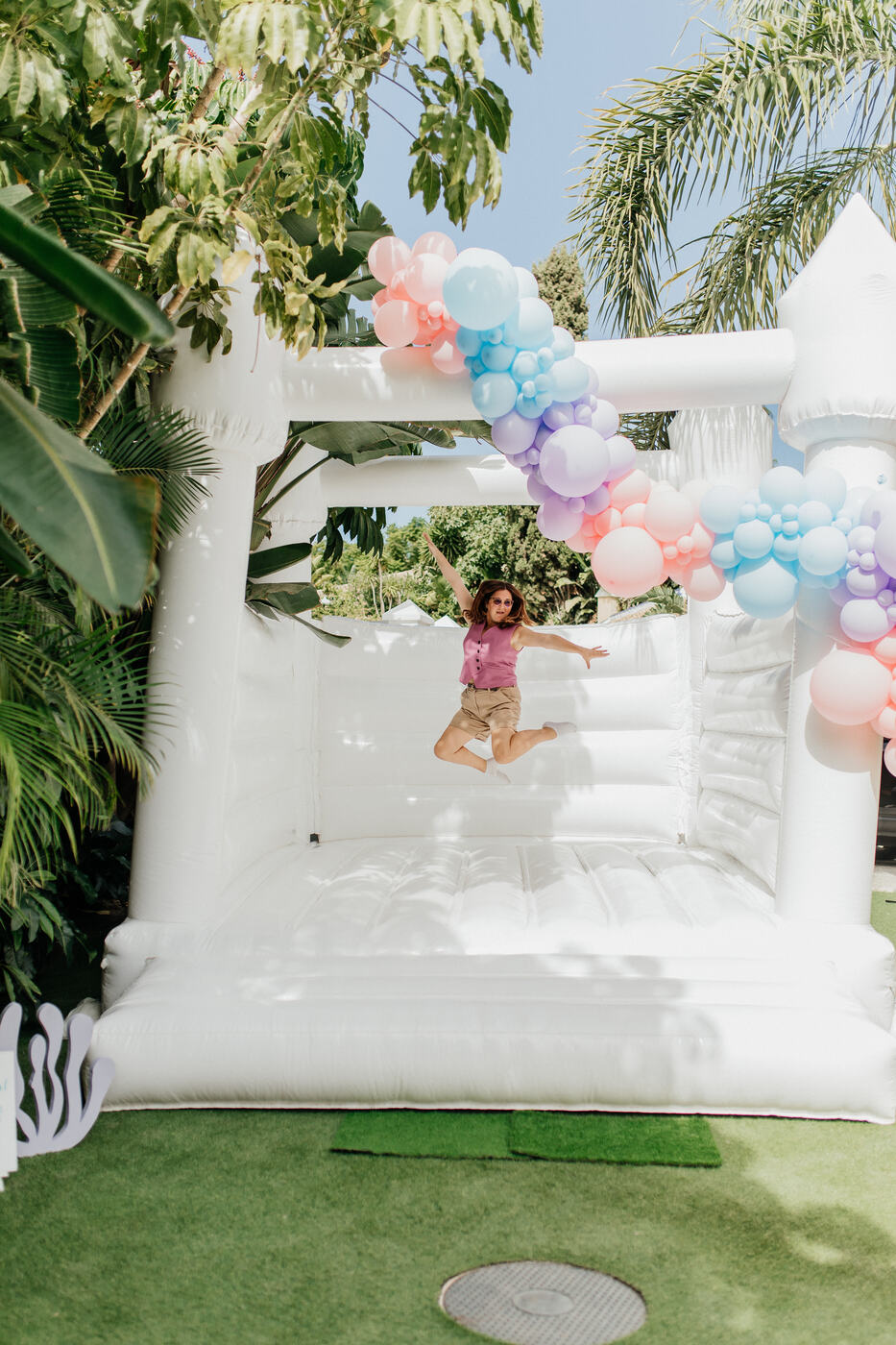 White bouncy castle with a pastel balloon garland at a Stitch themed kids' party, Marbella