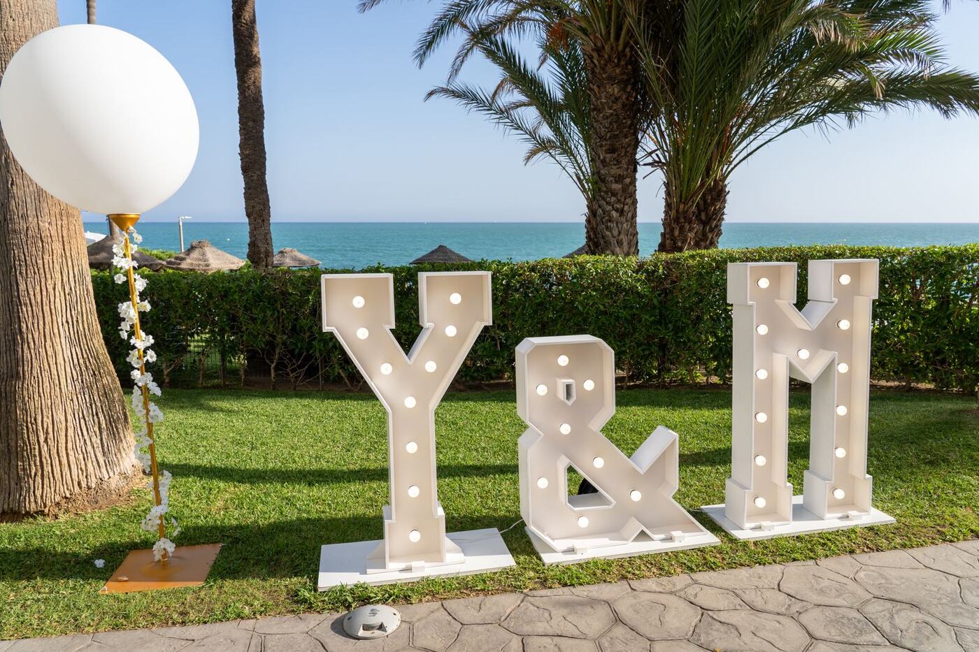 Y&M light-up marquee letters beside the beach in Marbella, wedding decor